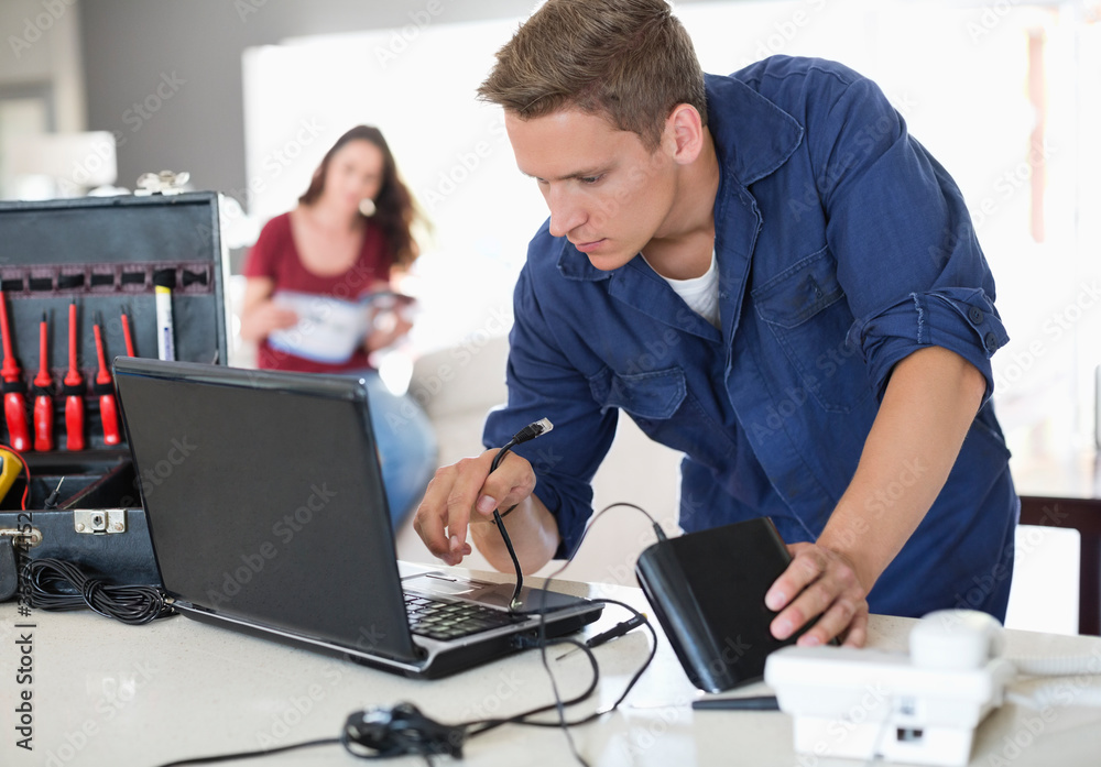 Electrician using laptop in home Electrician using laptop in home
