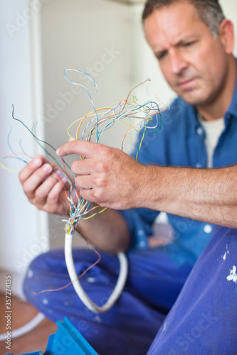 Electrician examining wires in kitchen
