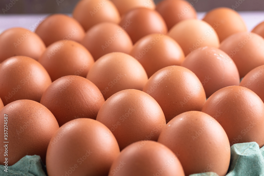 Box of red eggs on a rustic white table. Top view.