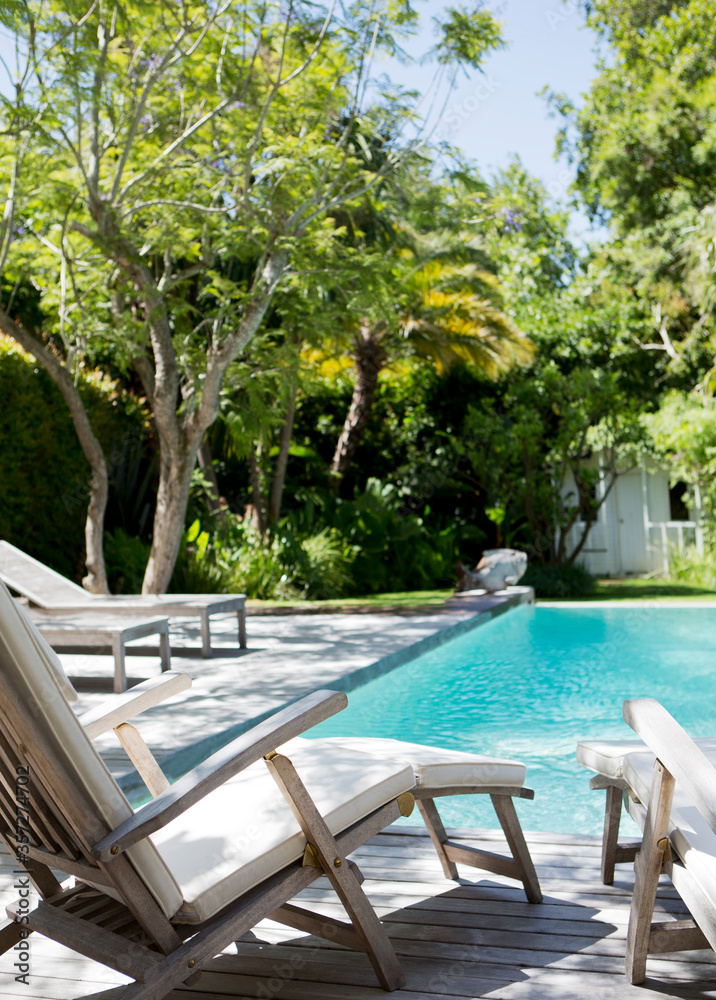 Fototapeta premium Lawn chairs and swimming pool in backyard