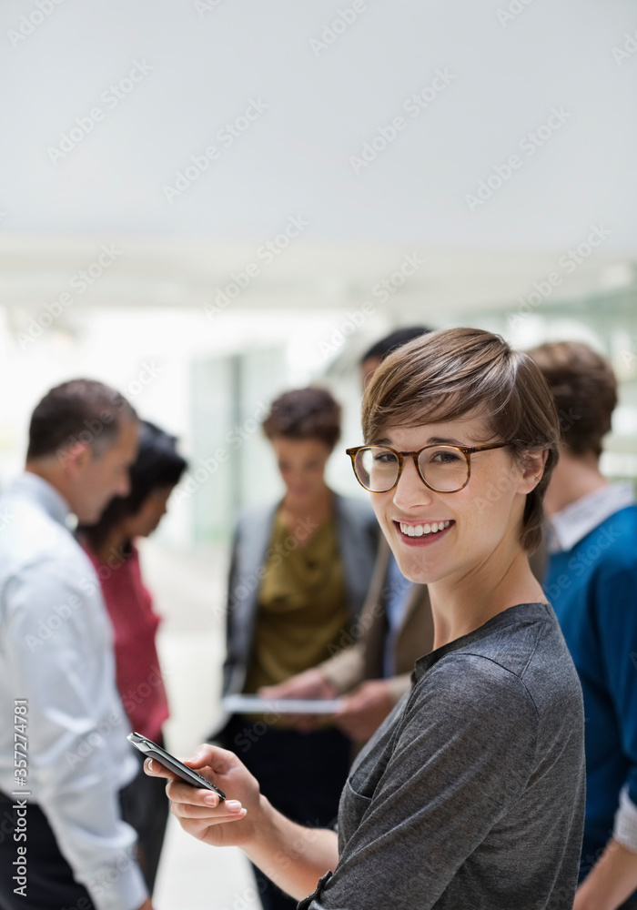 © Paul Bradbury/KOTO - Businesswoman using cell phone in meeting © Paul Bradbury/KOTO - Businesswoman using cell phone in meeting