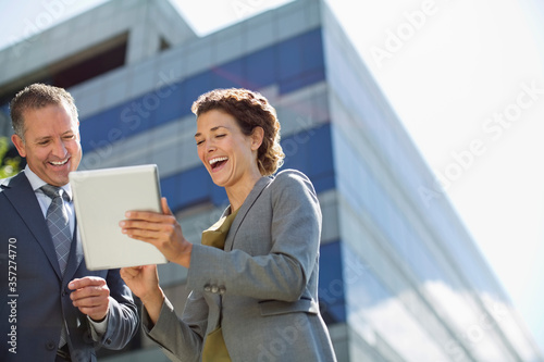 Business people using tablet computer outdoors