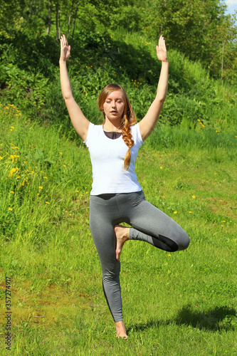 Young woman of European appearance does yoga in summer nature © Stanislav
