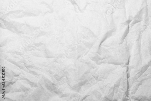 Single creased crumpled white napkin with shadows. Abstract Background © Alex Yakunina