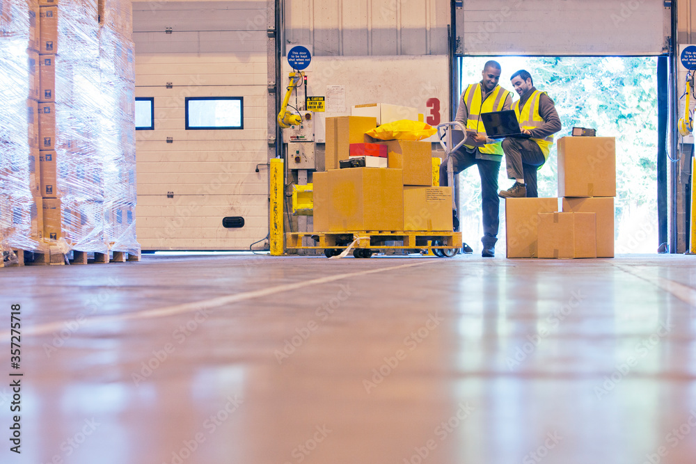 Workers checking boxes in warehouse Workers checking boxes in warehouse