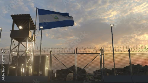 Waving flag of Nicaragua above military base in the evening photo