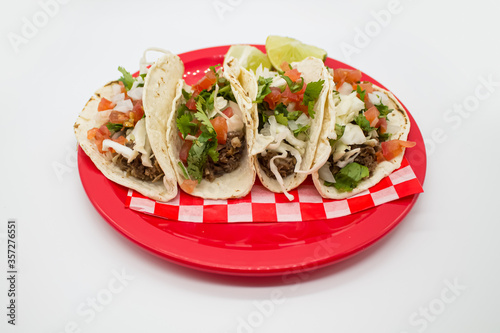 Obraz na płótnie Tacos y tortas de barbacoa sobre mantel de cuadros rojos y fondo blanco w salonie