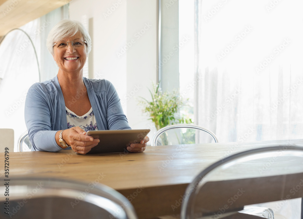 Older woman using tablet computer at table Older woman using tablet computer at table