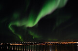 majestic aurora borealis over fjord, mountain and bridge in the arctic circle