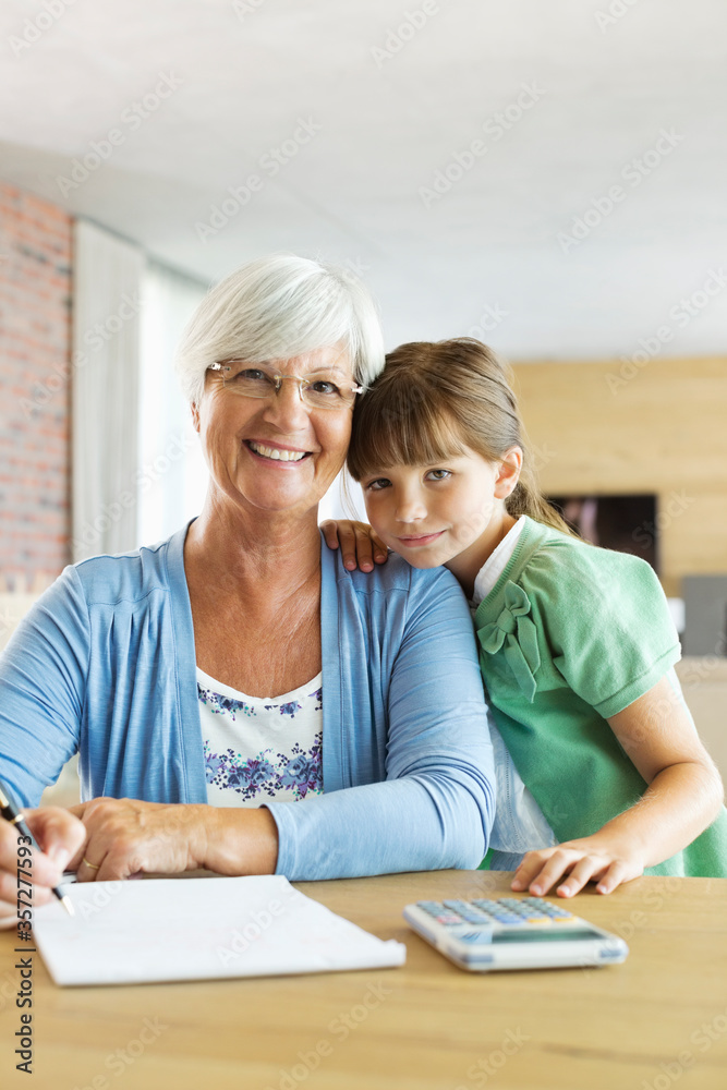 Older woman and granddaughter using calculator Older woman and granddaughter using calculator
