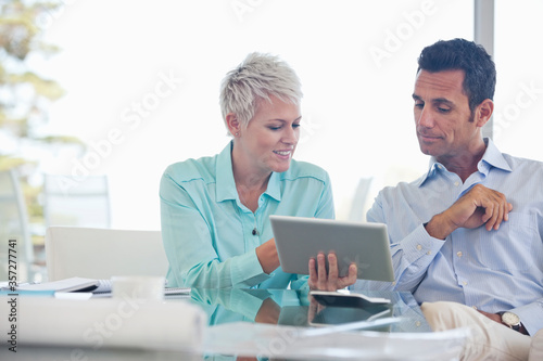 Business people using tablet computer on sofa