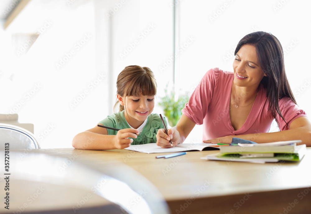 Mother helping daughter with homework Mother helping daughter with homework