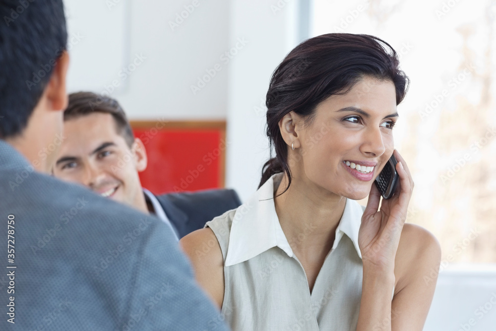 Businesswoman talking on cell phone in office Businesswoman talking on cell phone in office