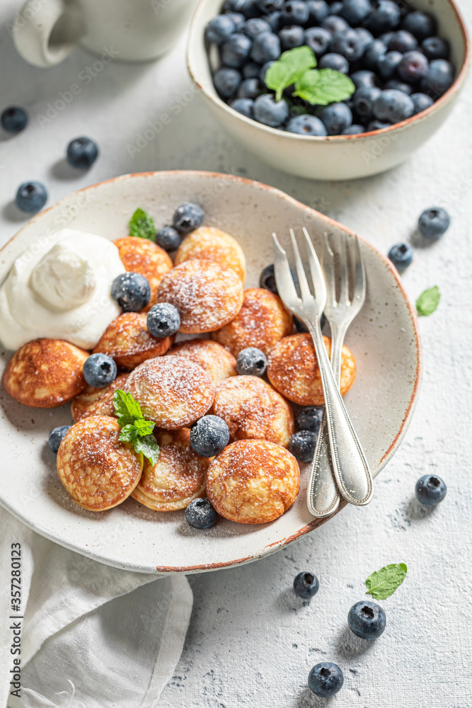 Delicious mini pancakes with fresh berries and powdered sugar Delicious mini pancakes with fresh berries and powdered sugar