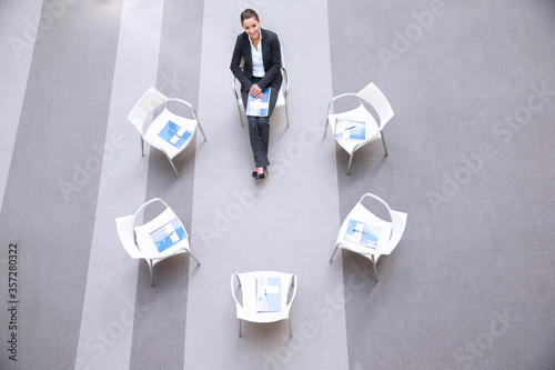 High angle portrait of smiling woman sitting at chair in circle photo