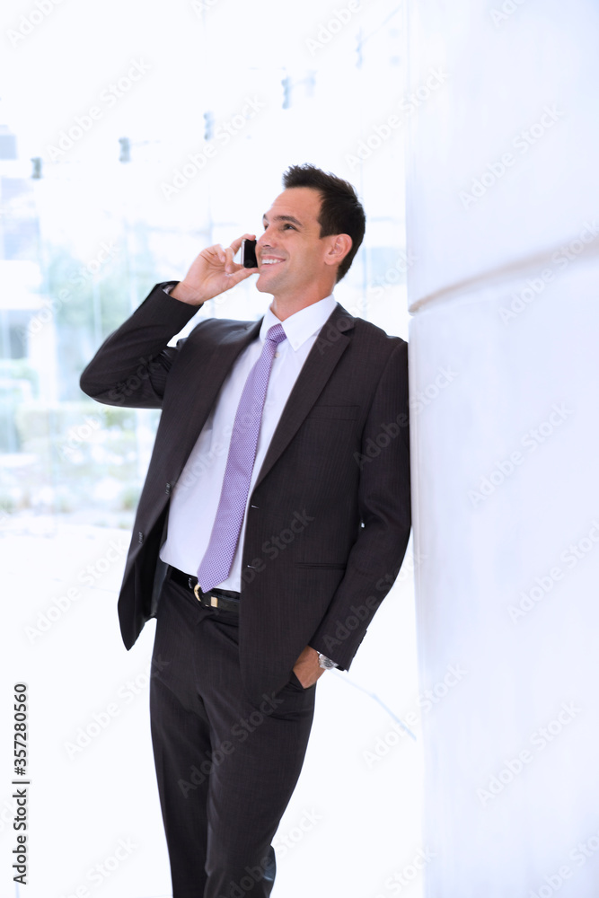Smiling businessman talking on cell phone
