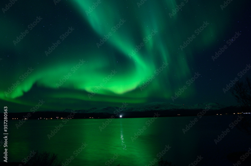 insanly strong aurora borealis over arctic fjord and mountain landscape