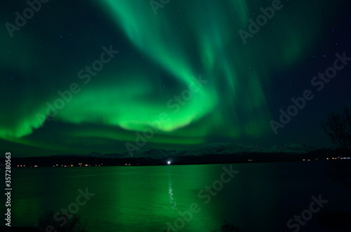 insanly strong aurora borealis over arctic fjord and mountain landscape © Arcticphotoworks