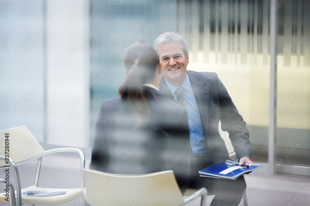 Fototapeta premium Smiling businessman talking to businesswoman