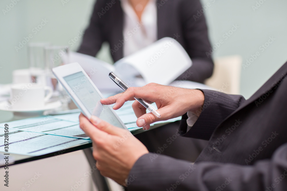 Close up of businessman using digital tablet in meeting Close up of businessman using digital tablet in meeting