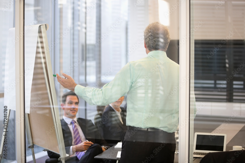 Businessman at flipchart in meeting Businessman at flipchart in meeting