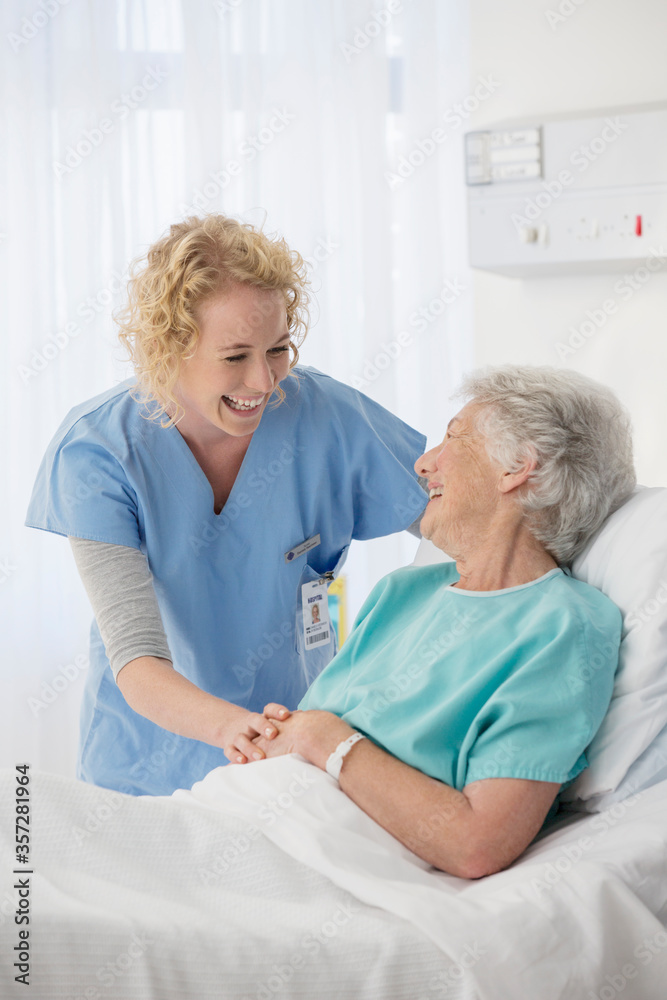Obraz premium Nurse and senior patient talking in hospital room