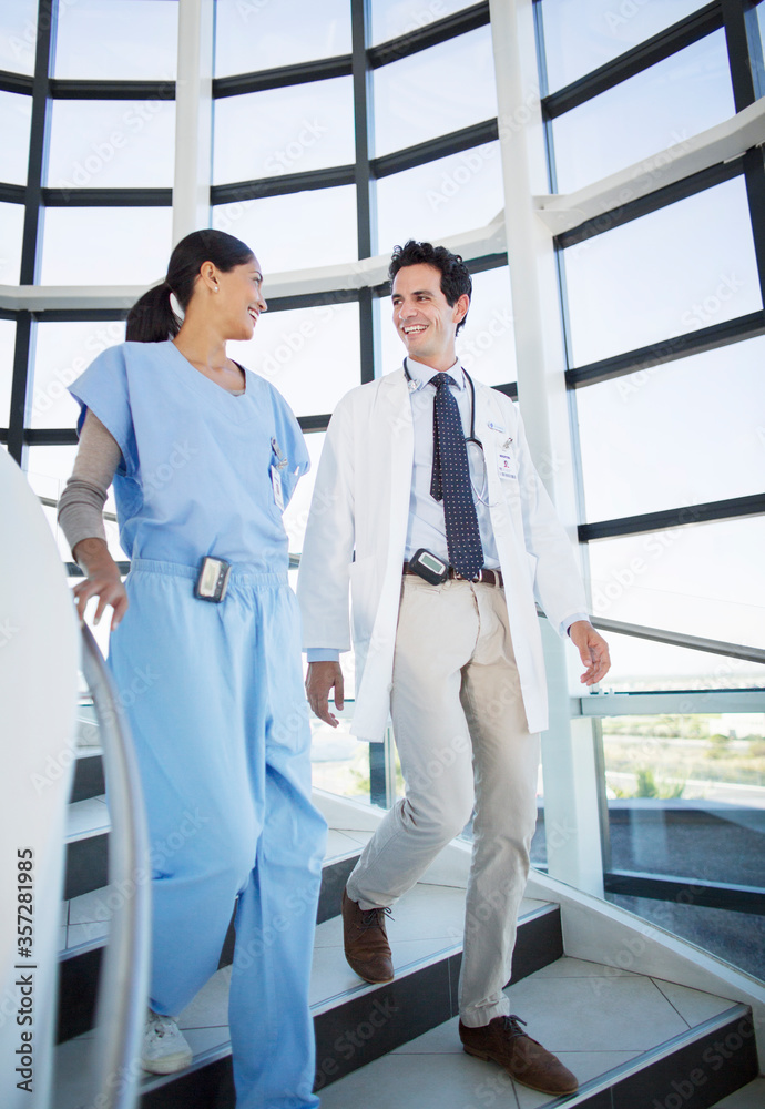 Doctor and nurse talking on staircase Doctor and nurse talking on staircase