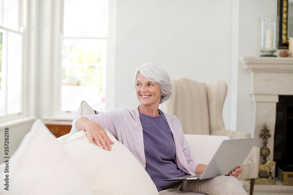 Senior woman using laptop on sofa Senior woman using laptop on sofa