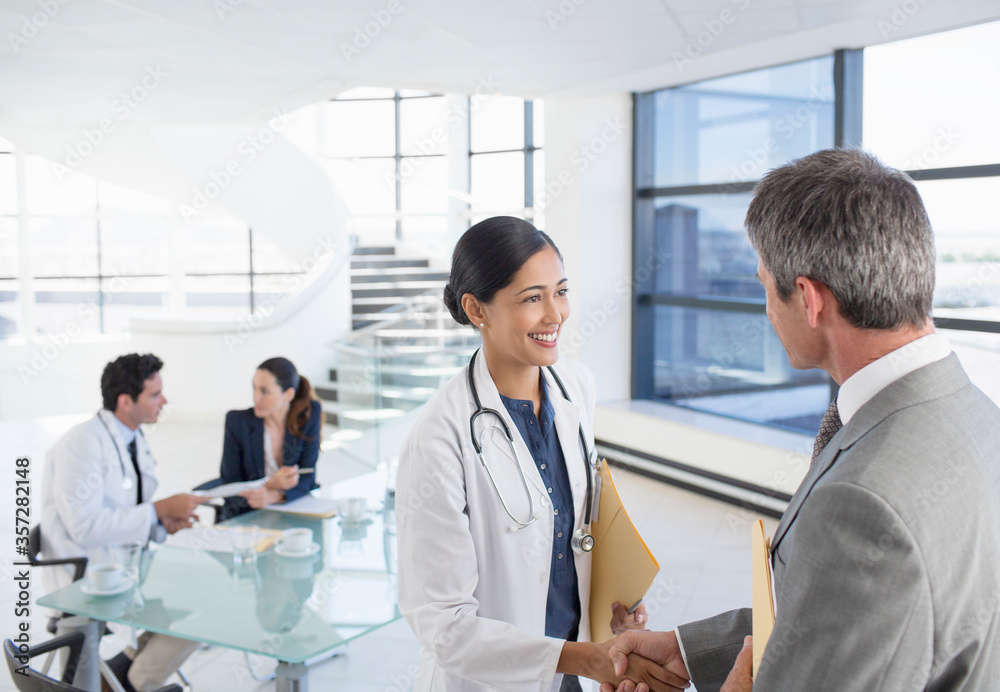 Doctor and businessman handshaking in meeting Doctor and businessman handshaking in meeting
