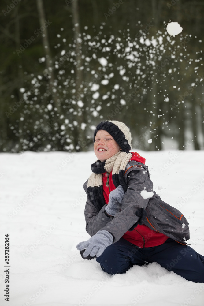 Portrait of happy boy enjoying snowball fight