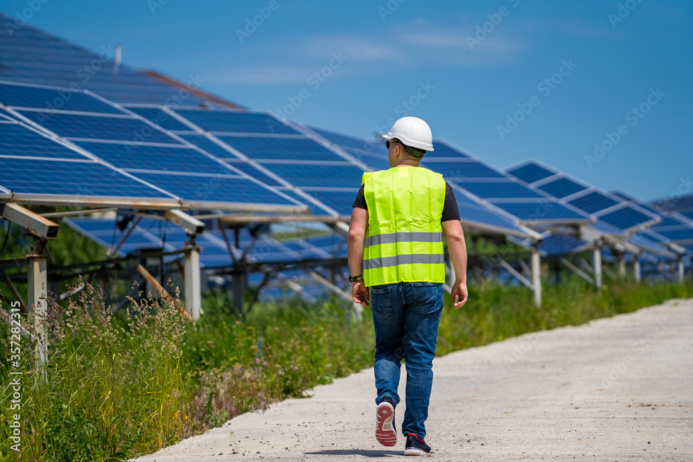 Engeneer in worker helmet on solar panels background. Solar power panel. Green energy. Electricity. Power energy pannels.