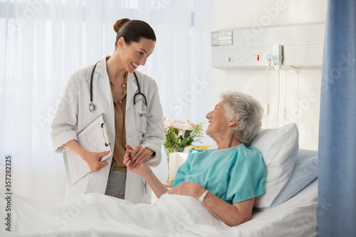 Bild auf Leinwand Doctor and senior patient talking in hospital room