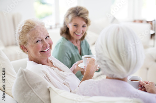 Senior women drinking coffee on sofa