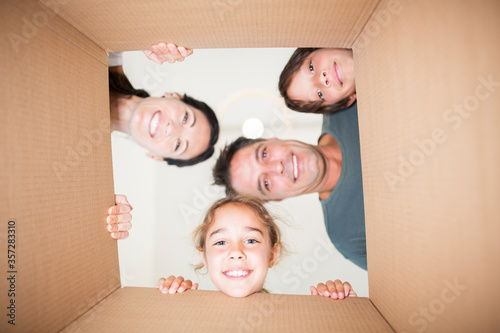Obraz na plátne Family looking down at camera through cardboard box
