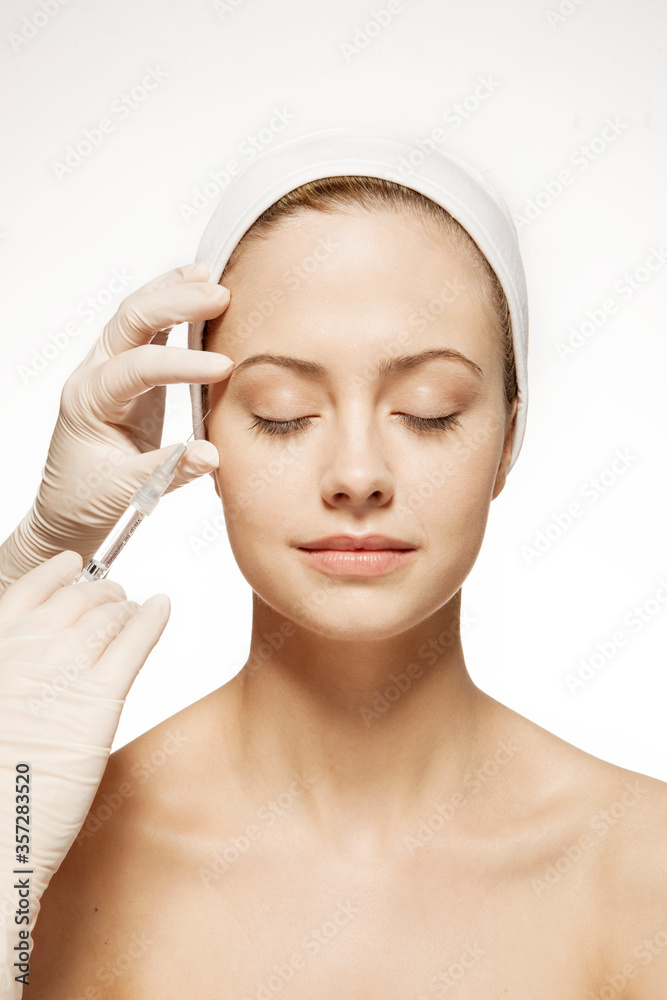 Doctor injecting botox into woman's face Doctor injecting botox into woman's face
