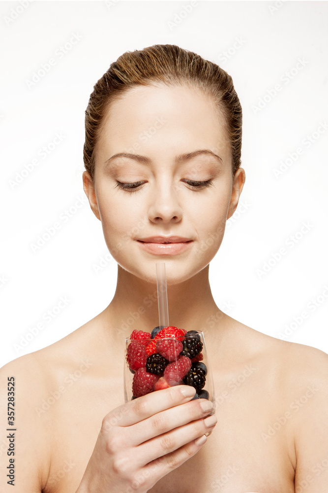 Woman drinking glass of berries Woman drinking glass of berries