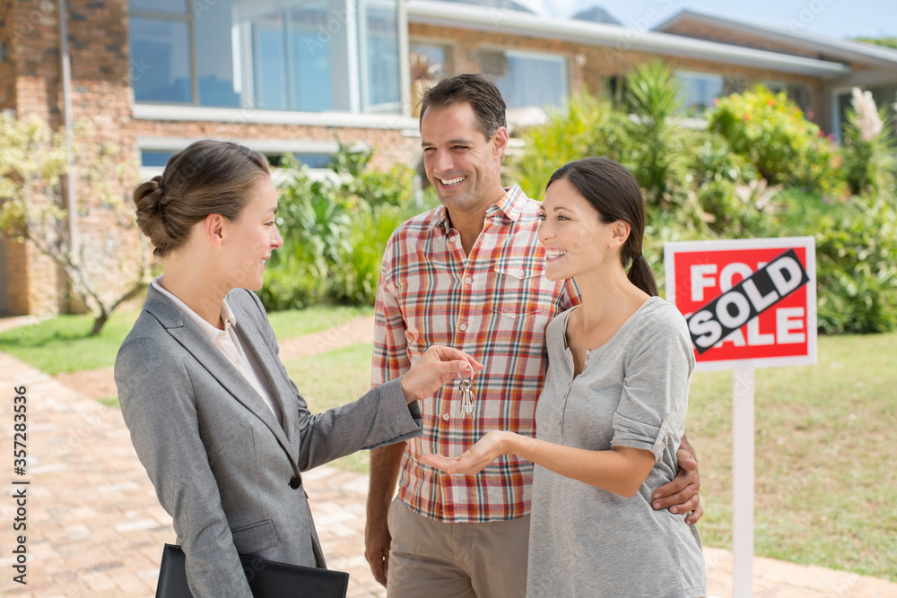 Realtor giving couple keys to new house Realtor giving couple keys to new house