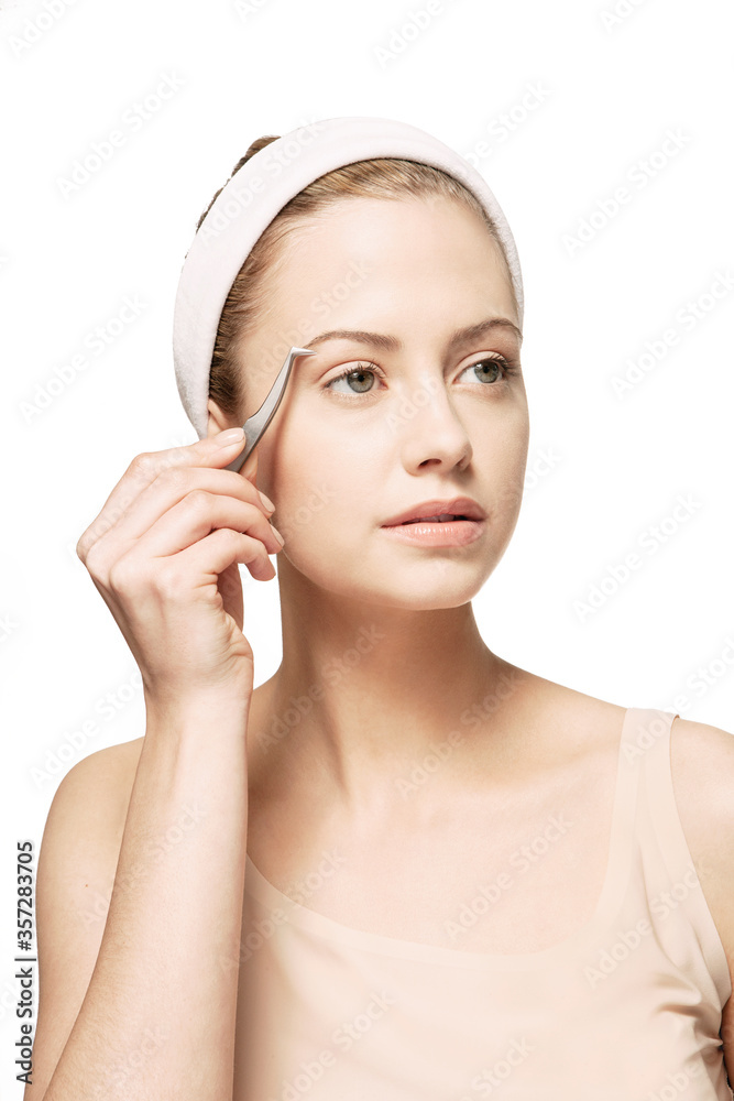 Woman plucking her eyebrows Woman plucking her eyebrows