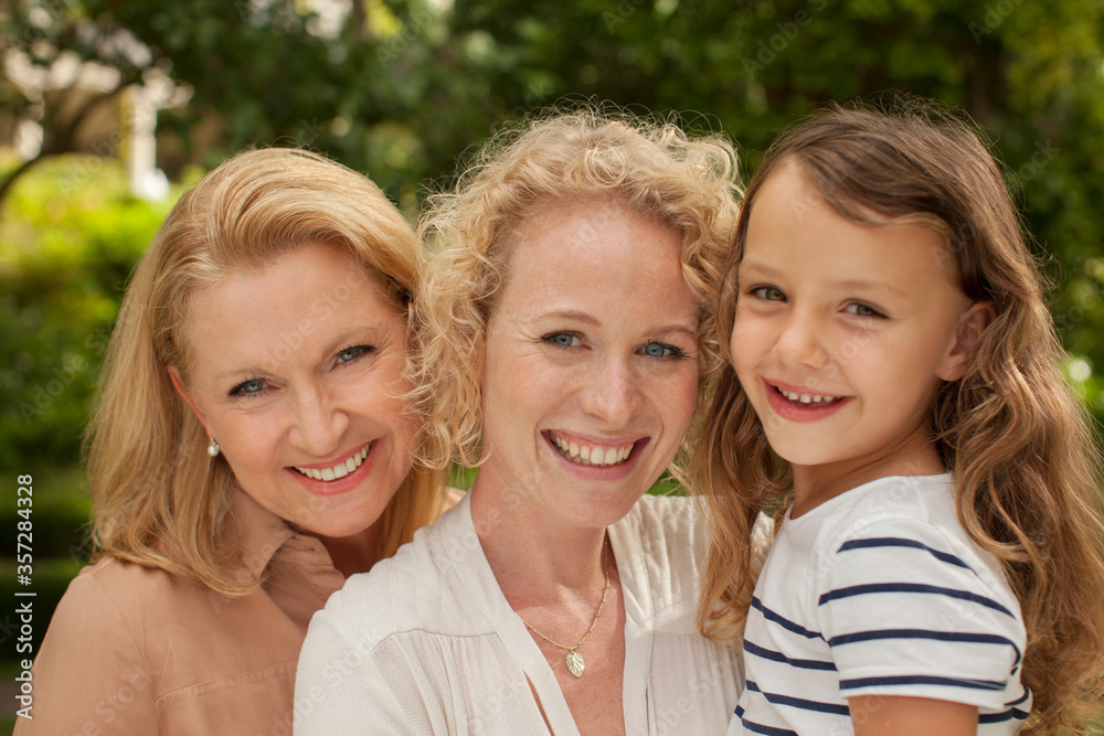 Three generations of women smiling outdoors Three generations of women smiling outdoors