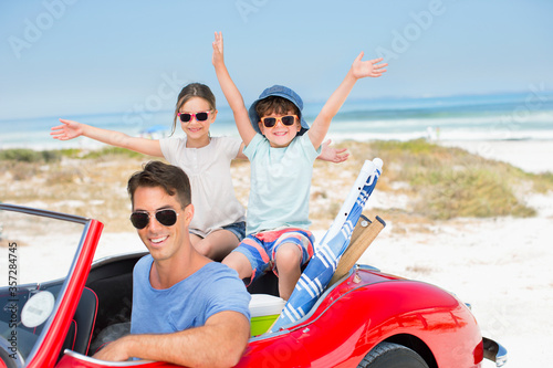 Father and children smiling in convertible at beach © Dan Dalton/KOTO