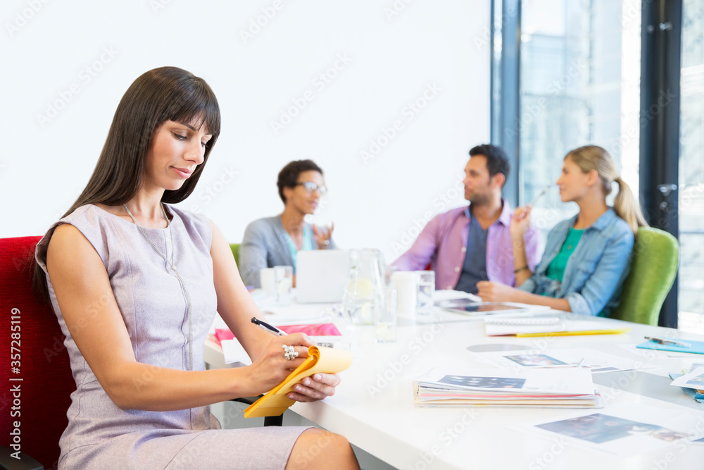 Businesswoman taking notes in meeting Businesswoman taking notes in meeting