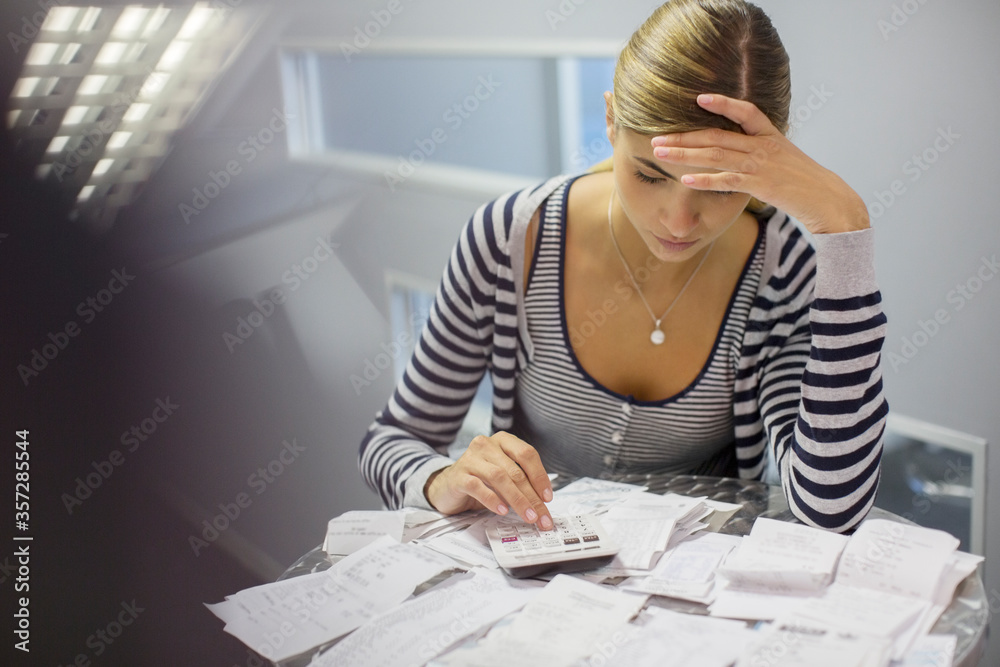 Frustrated woman paying bills Frustrated woman paying bills