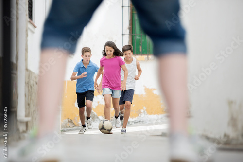 Children playing with soccer ball in alley © Tom Merton/KOTO