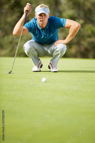Photography Man preparing to putt on golf course
