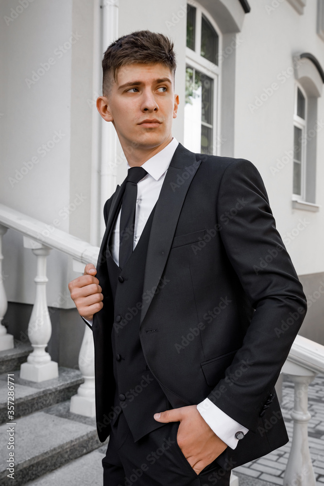 Handsome elegant young fashionable man in a tuxedo coat. Classic suit. Suit and tie. Handsome elegant young fashionable man in a tuxedo coat. Classic suit. Suit and tie.