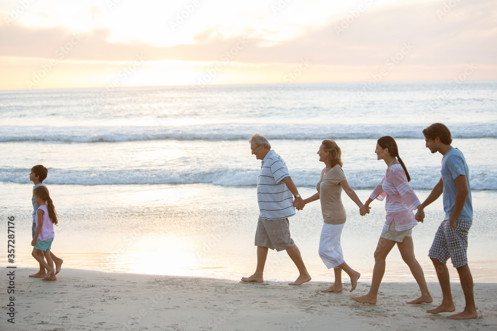 Multi-generation family walking on beach