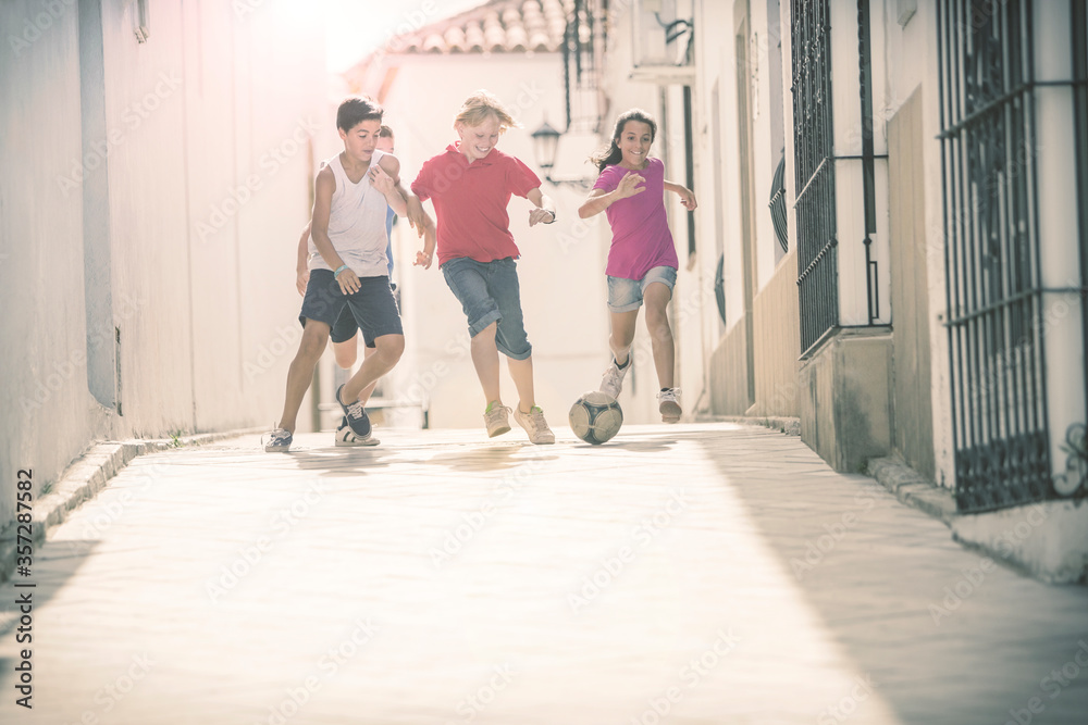 Children playing with soccer ball in alley Children playing with soccer ball in alley