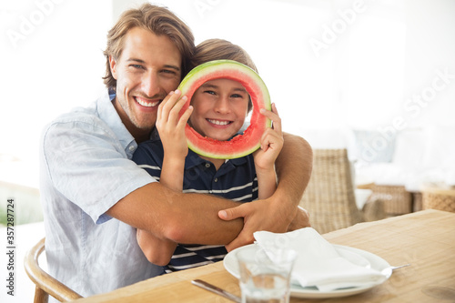 Father and son playing with food at table