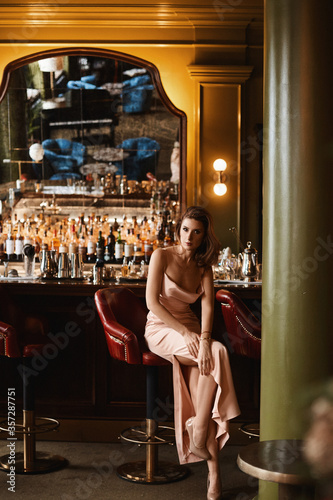 A young woman in evening dress spending time alone in a restaurant interior
