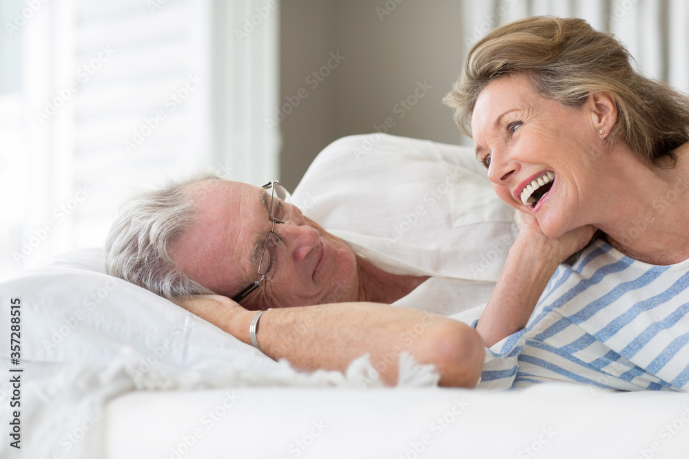 Older couple relaxing on bed - obrazy, fototapety, plakaty 